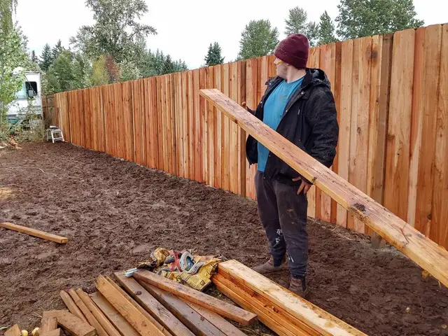 Completed full-length cedar dog-ear privacy fence in a rural Estacada, OR backyard — Devine Home Remodeling & Construction