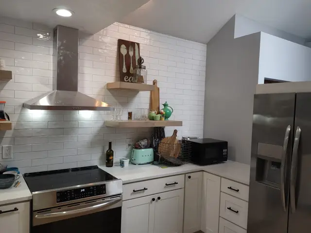 Remodeled kitchen with white shaker cabinets, subway tile, and stainless range hood near Estacada, OR — Devine Home Remodeling & Construction