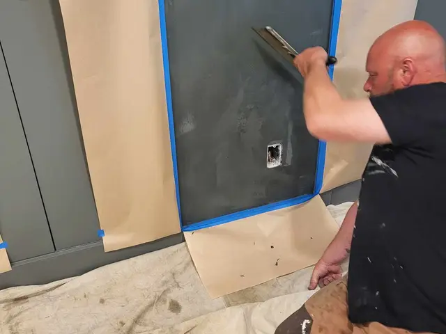 Craftsman troweling Venetian plaster onto a deep-blue accent wall near Estacada, OR — Devine Home Remodeling & Construction