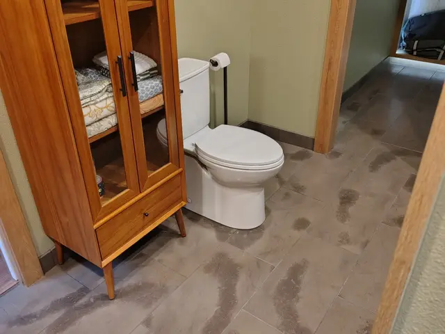 Bathroom storage cabinet and toilet area with matching wood finish near Estacada, OR — Devine Home Remodeling & Construction