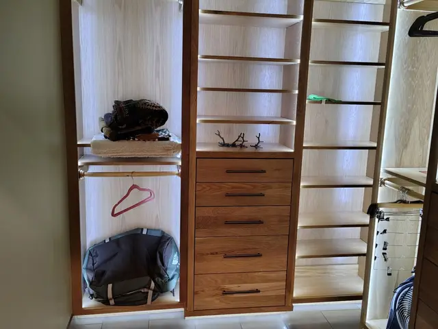 Custom walk-in closet system with illuminated shelving and wood drawer bank near Estacada, OR — Devine Home Remodeling & Construction