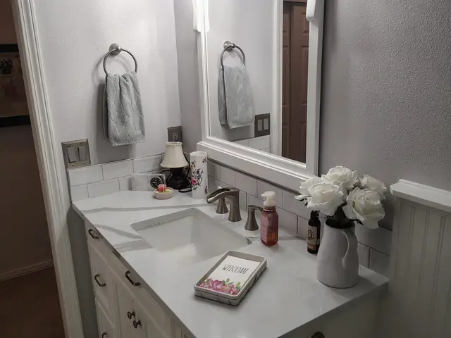 Guest bathroom vanity with quartz countertop and framed mirror near Estacada, OR — Devine Home Remodeling & Construction