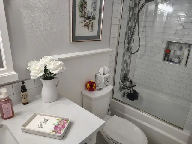 Guest bathroom view from vanity toward the tiled tub-shower combo near Estacada, OR — Devine Home Remodeling & Construction